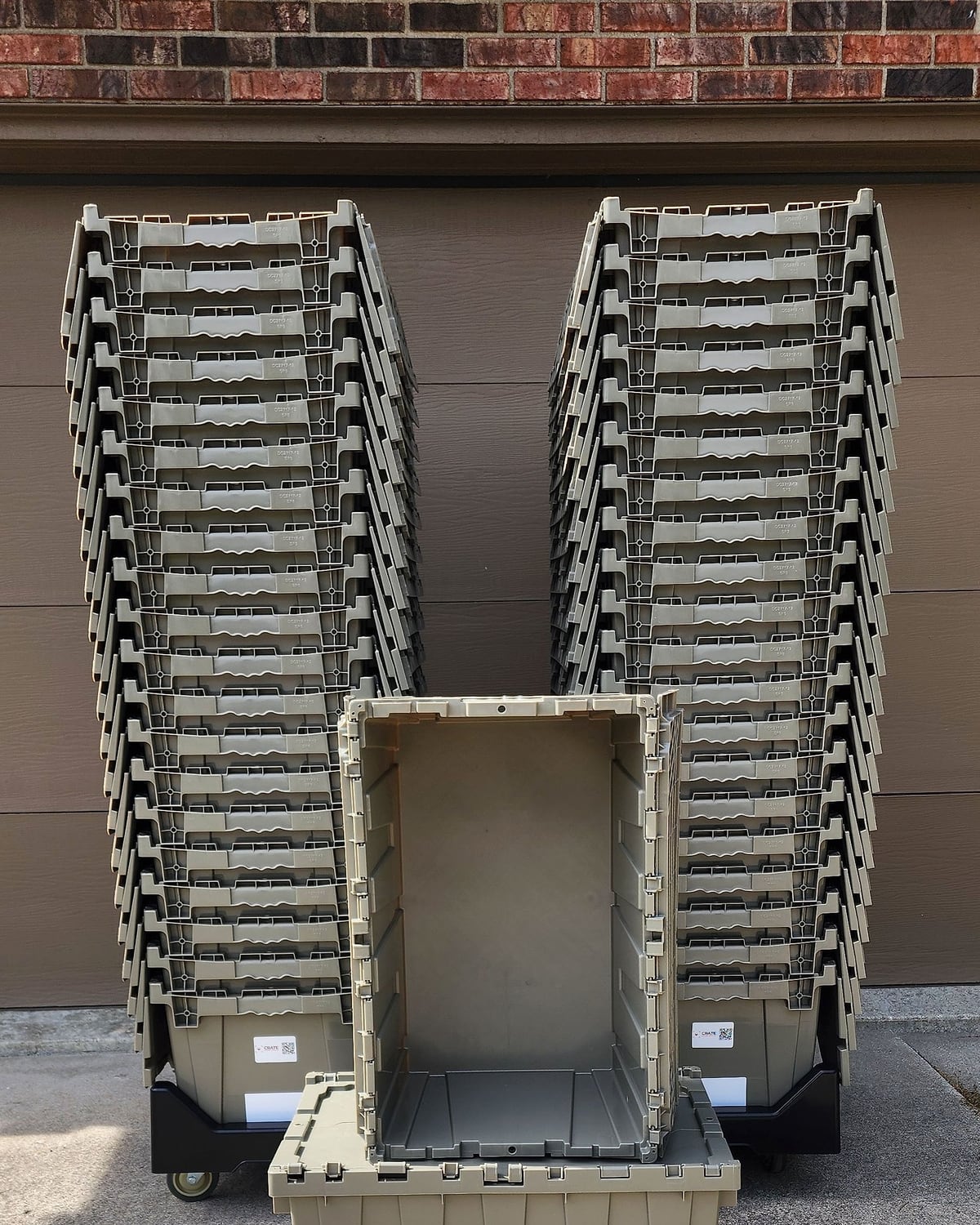 Two dollies of nested moving totes with one tote open in front, showing the empty inside